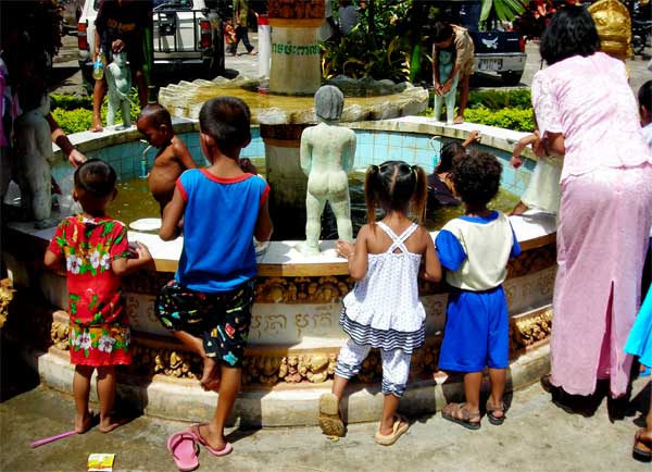 kids at a fountain at wat kraom